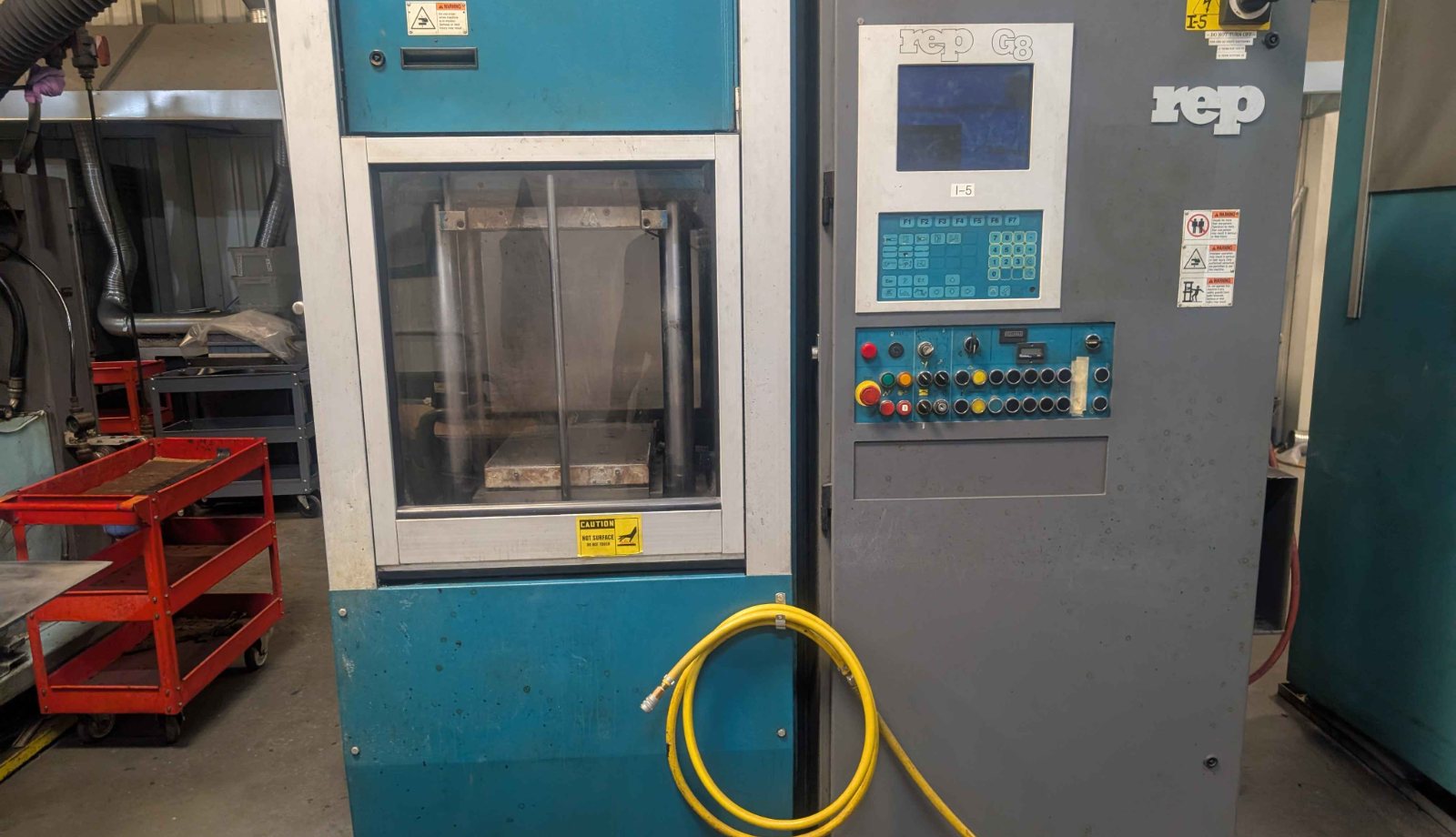 REP G8 injection molding machine control panel on a plant floor